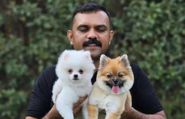 holding two puppies